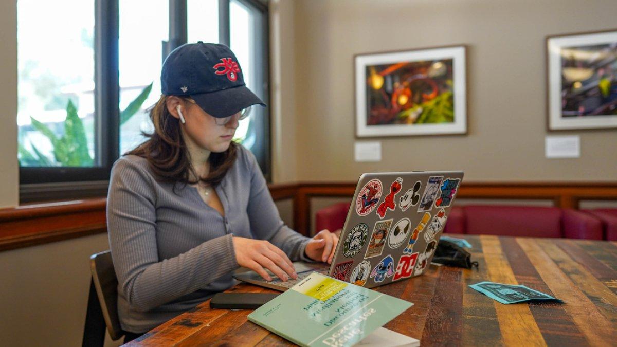 SMC学生在咖啡厅用笔记本电脑工作